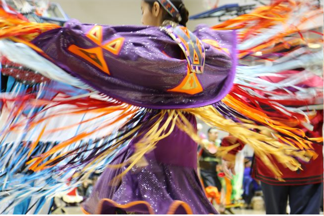 A dancer spins at a pow wow held at the University of Toronto