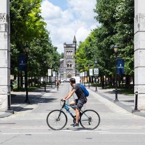 Student riding a bike in front of front campus