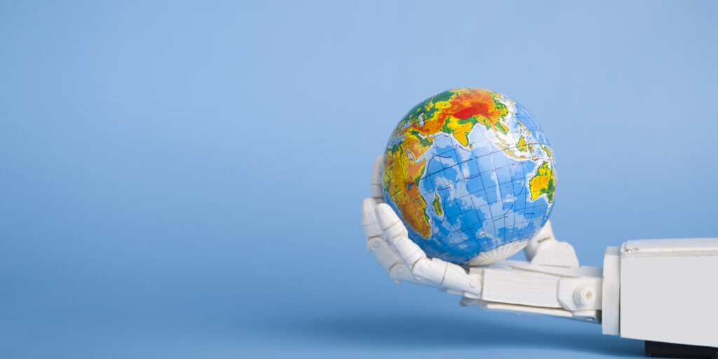 Global automatization concept. Earth globe in robotic hand, blue panorama background with copy space